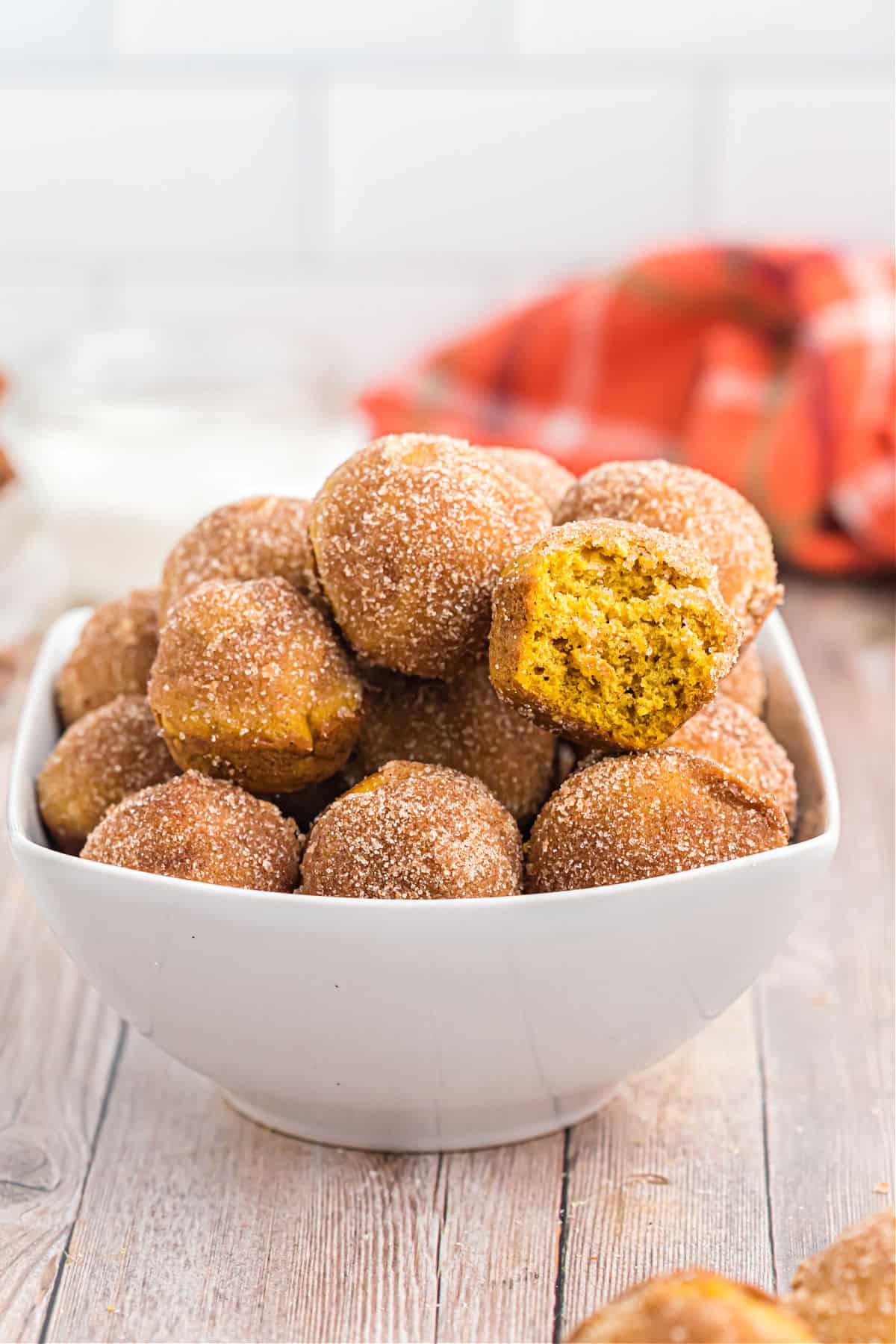 Bowl of donut holes in a white bowl.