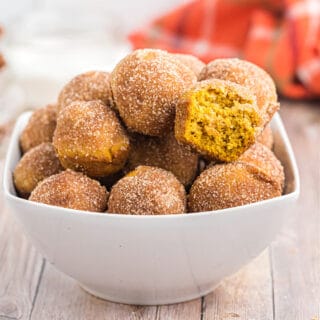 Bite sized Pumpkin Donut Muffins! Roll your baked pumpkin mini donuts in butter and cinnamon sugar for a bite sized breakfast treat no one can resist.