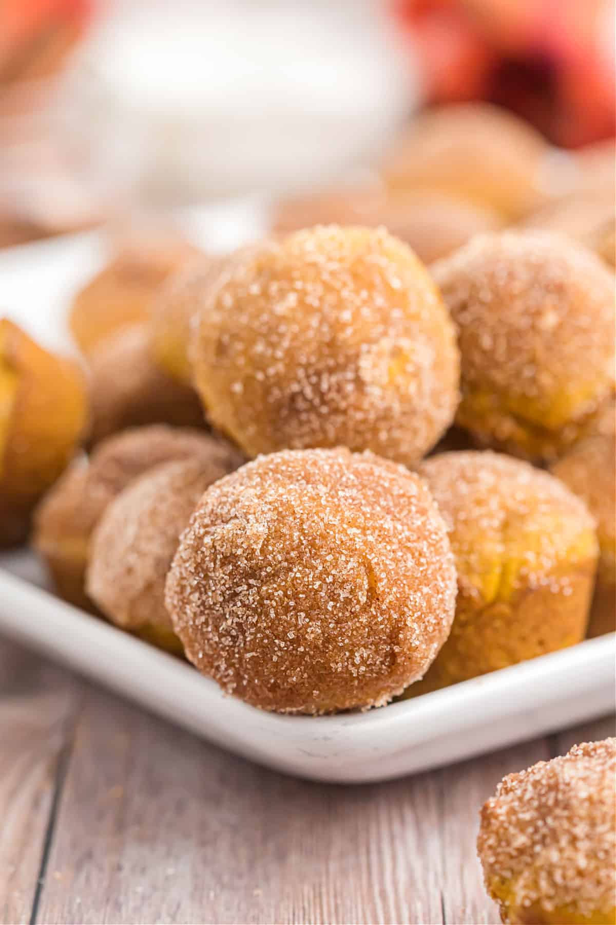 White plate with mini pumpkin donuts stacked on top.