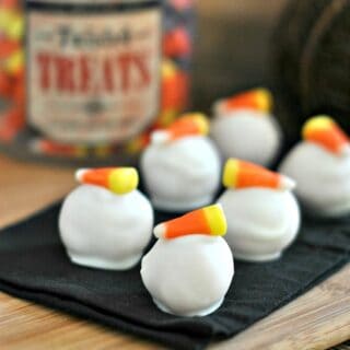 Oreo balls dipped in white chocolate and topped with a piece of candy corn.