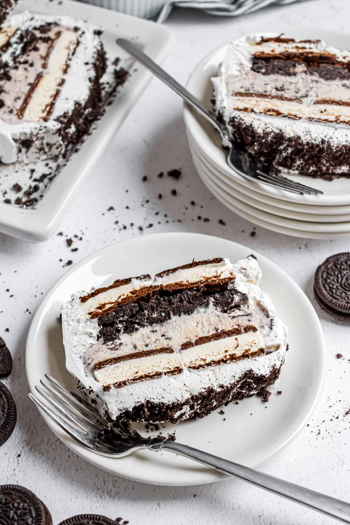 Oreo ice cream cake sliced and served on white plates.