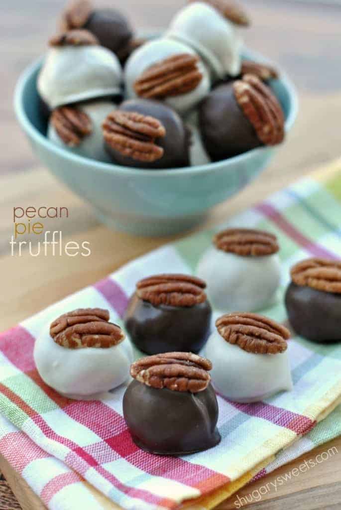 Pecan Pie Truffles: delicious bites of pecan pie in a chocolate truffle coating! #ThinkFisher Pecan pie truffles on colorful napkin topped with a pecan halve.
