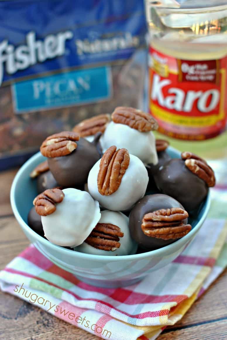 Pecan Pie Truffles in a blue bowl with corn syrup and pecans in background.