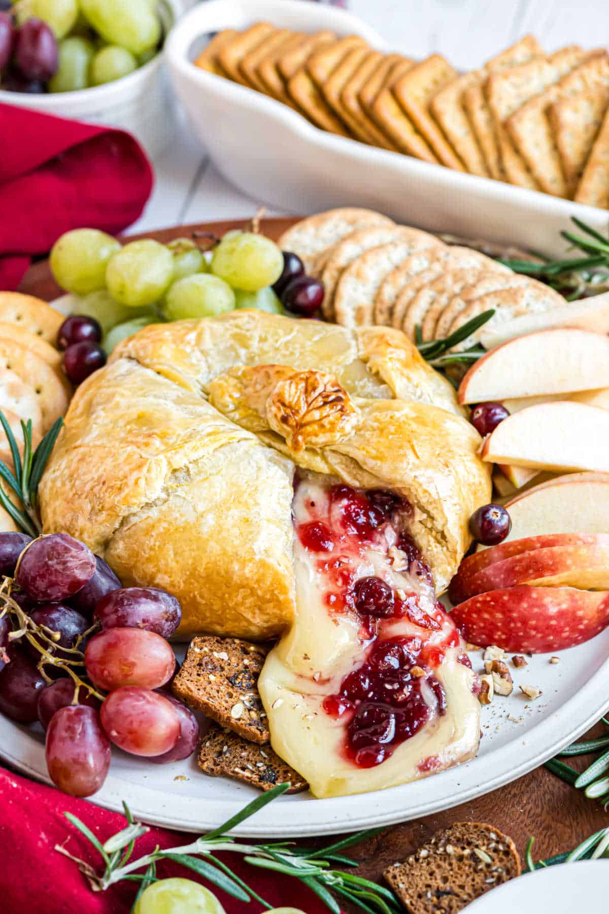 Brie with cranberries and pecans oozing out of baked puff pastry.