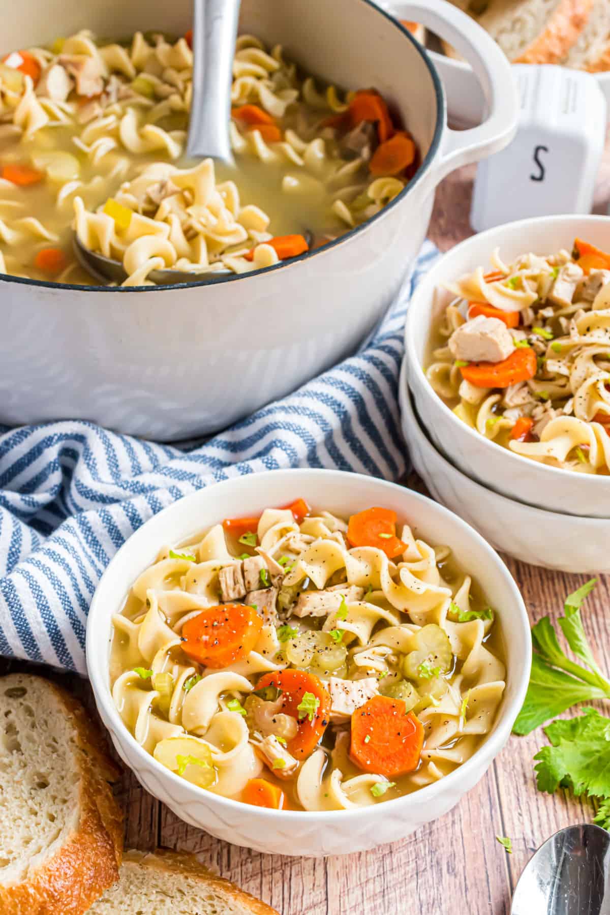 Turkey noodle soup served in white bowls.