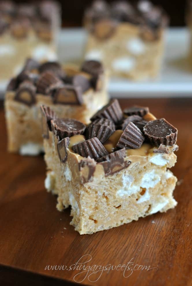 Fluffernutter rice krispie treat on a wooden cutting board. Topped with Reese's peanut butter cups.