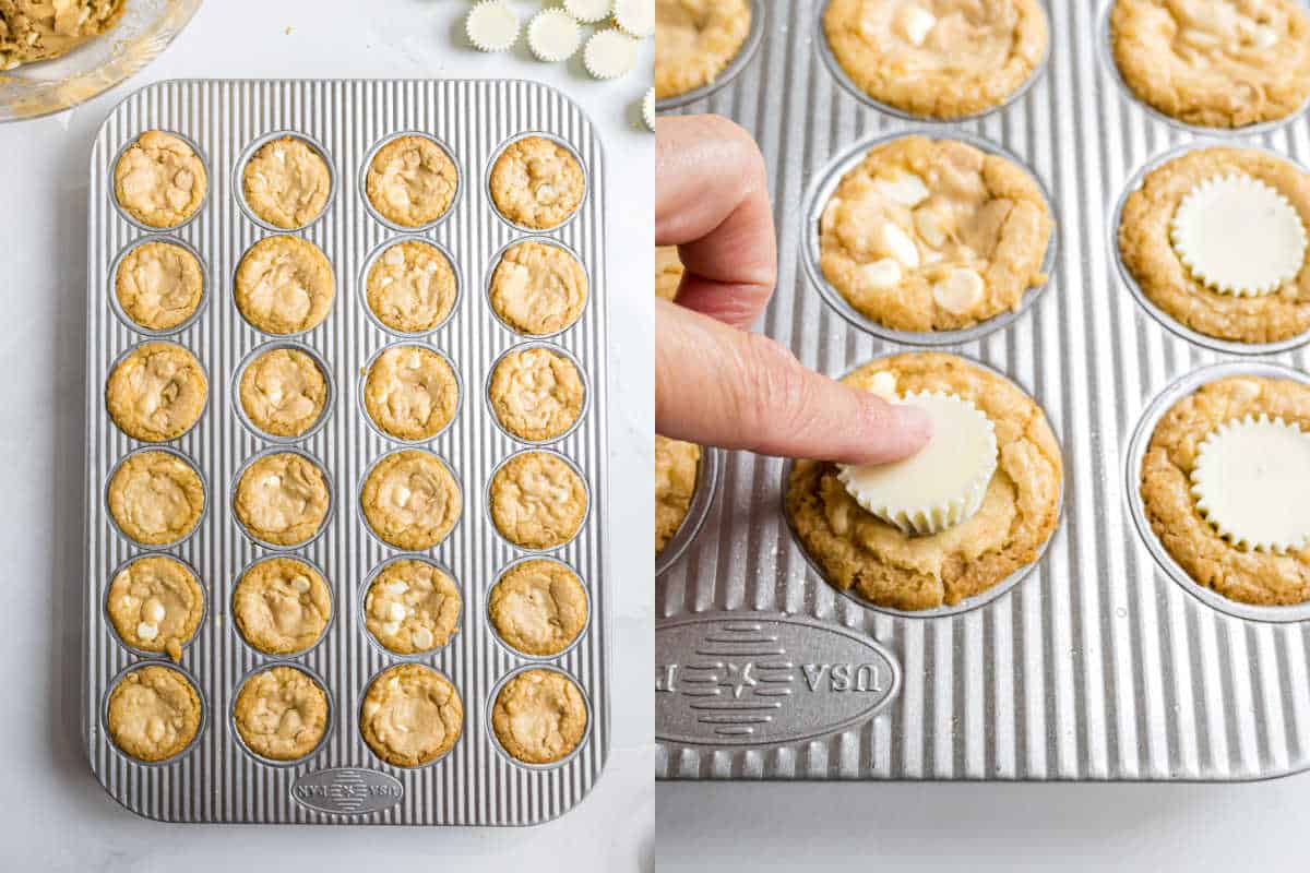 Mini white chocolate peanut butter cookies in a muffin tin, with a hand pressing a white chocolate candy into one of the warm cookie cups.