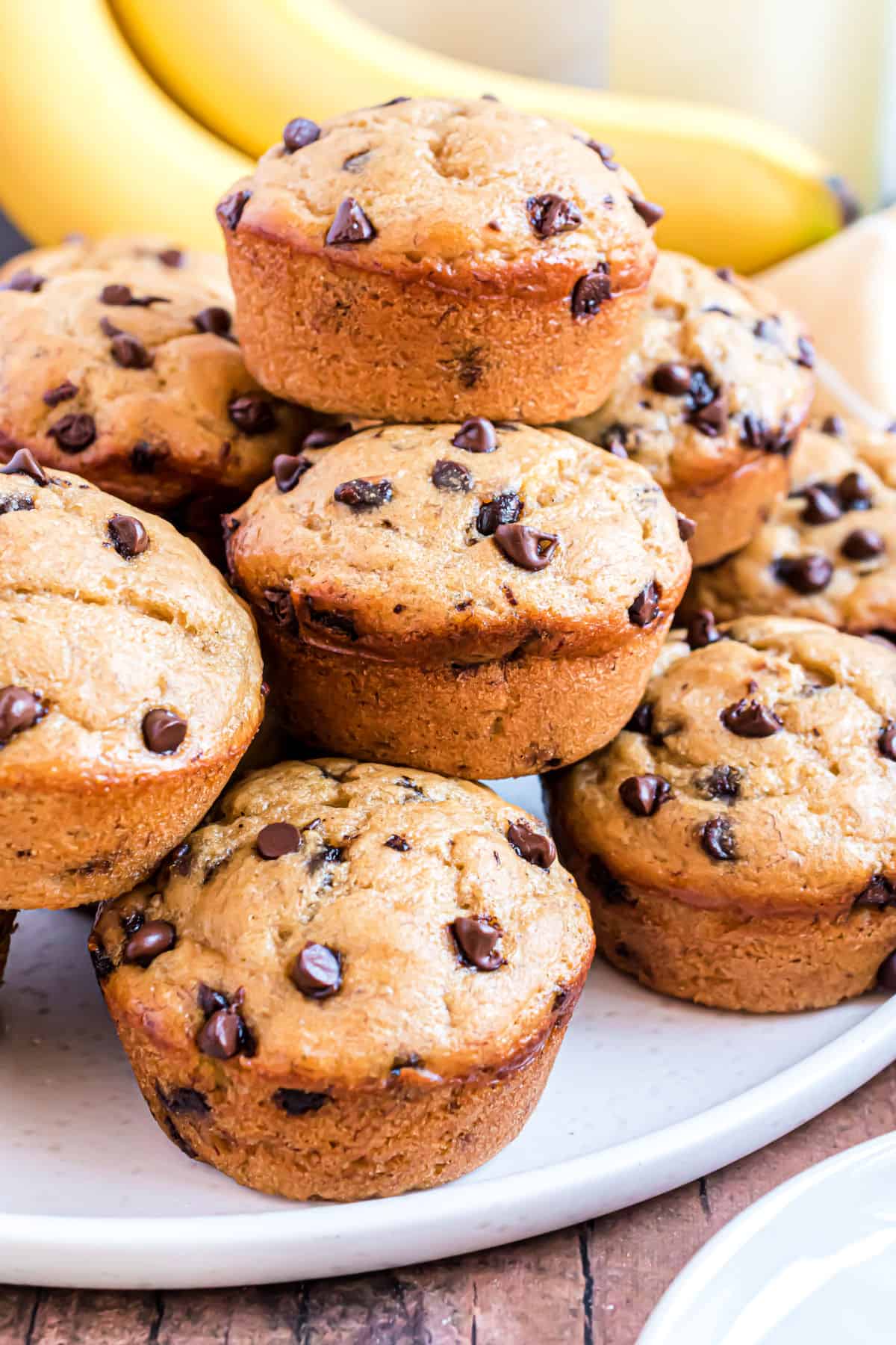 Stack of banana chocolate chip muffins on a plate.