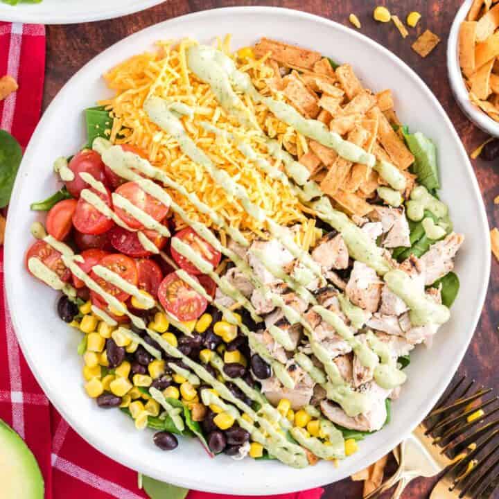 This Southwest Chicken Salad is a hearty mix of fresh veggies and chicken. Black beans, cheese and a creamy avocado dressing give even more southwestern flair to your colorful meal!