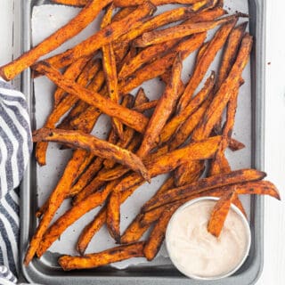 Crunchy Roasted Sweet Potato Fries with a spicy kick! Don't forget to pair this with a sweet and spicy Cinnamon dipping sauce! Easy to make and the perfect dinner side dish.