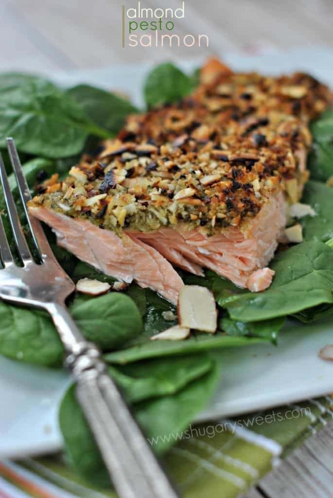 Flaky baked salmon recipe with basil pesto and almonds. So easy and delicious! #thinkfisher #salmon Baked Salmon with Almonds and Pesto on bed of spinach