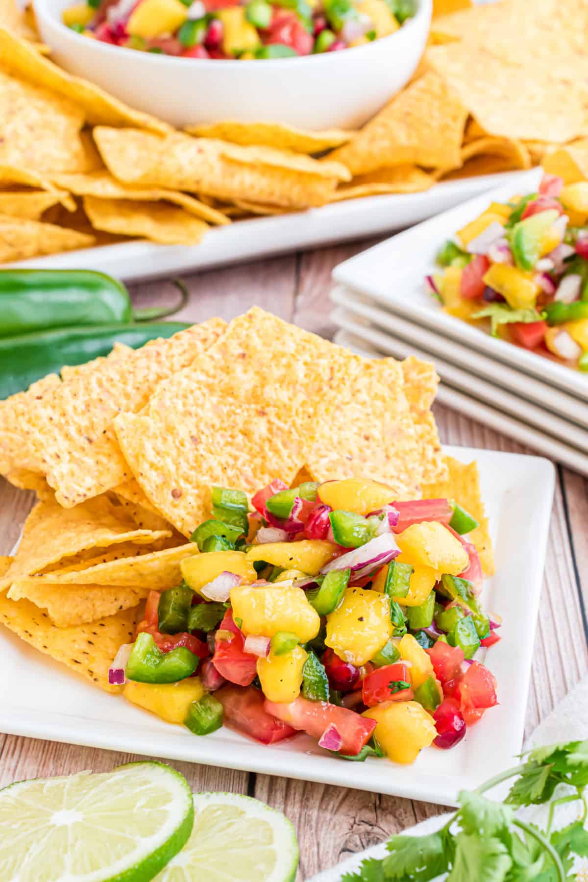 Mango salsa served on a plate with tortilla chips.