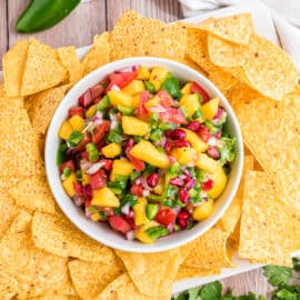 Mango salsa with tortilla chips on a platter.