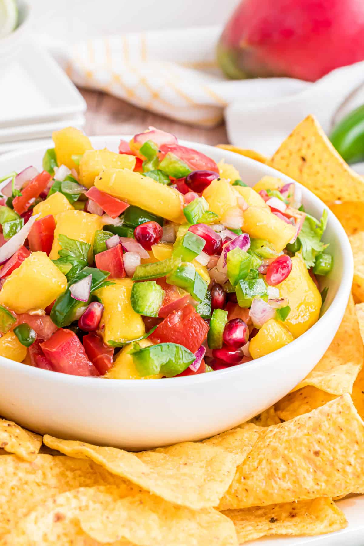Mango salsa served in a white bowl with tortilla chips.