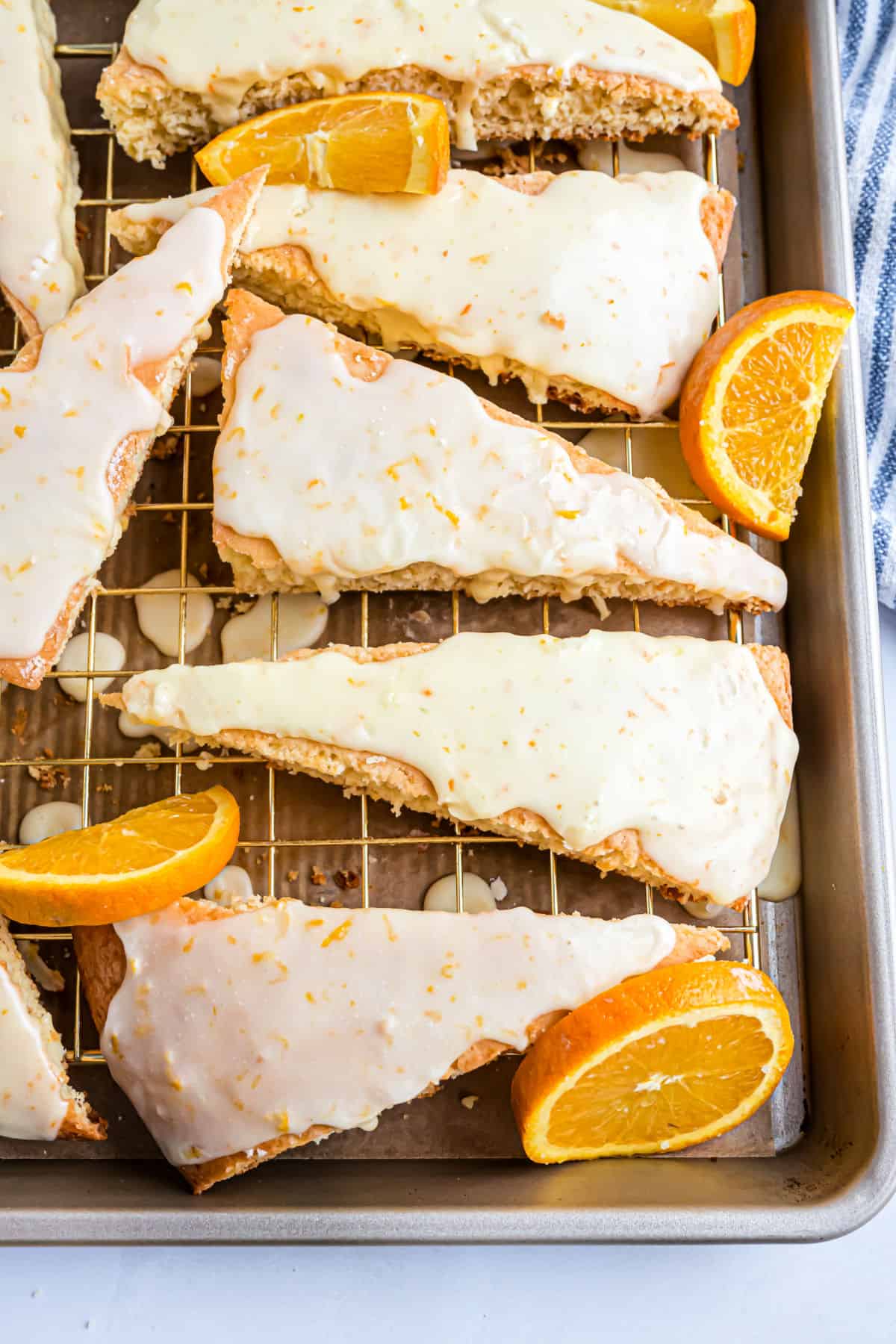 Scones on a baking sheet with slices of oranges.