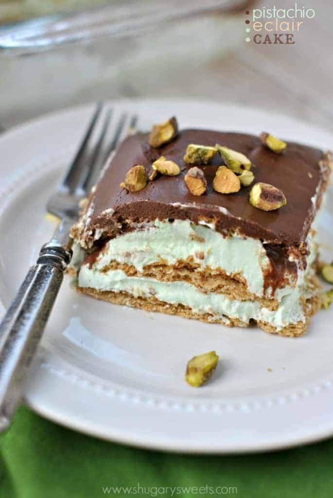 Slice of pistachio eclair dessert cake on a white plate.