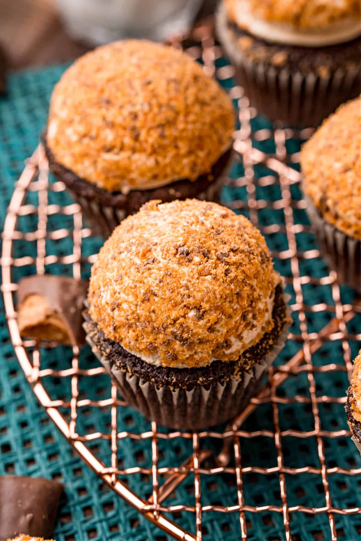 Cooling rack with butterfinger frosted chocolate cupcakes.