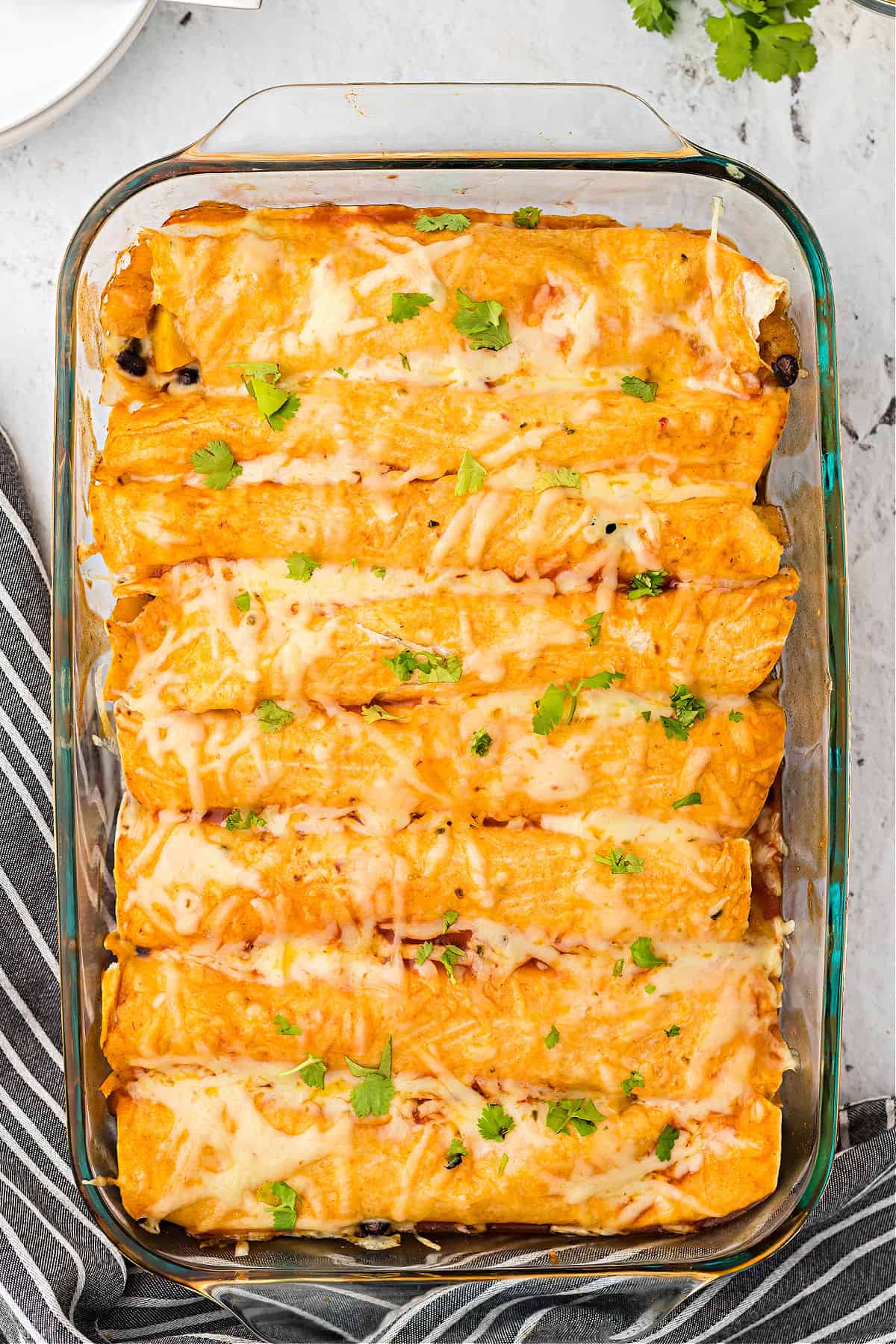 Butternut squash and black bean enchiladas baked in a 13x9 dish.