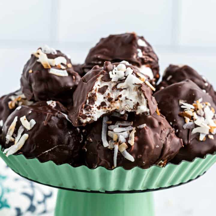 Coconut truffles served on a green cake platter.