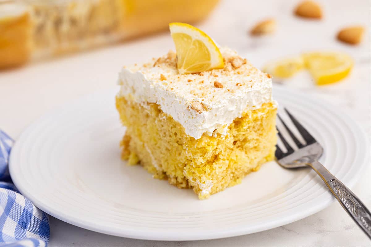 Slice of lemon cake topped with lemon jello and whipped cream.