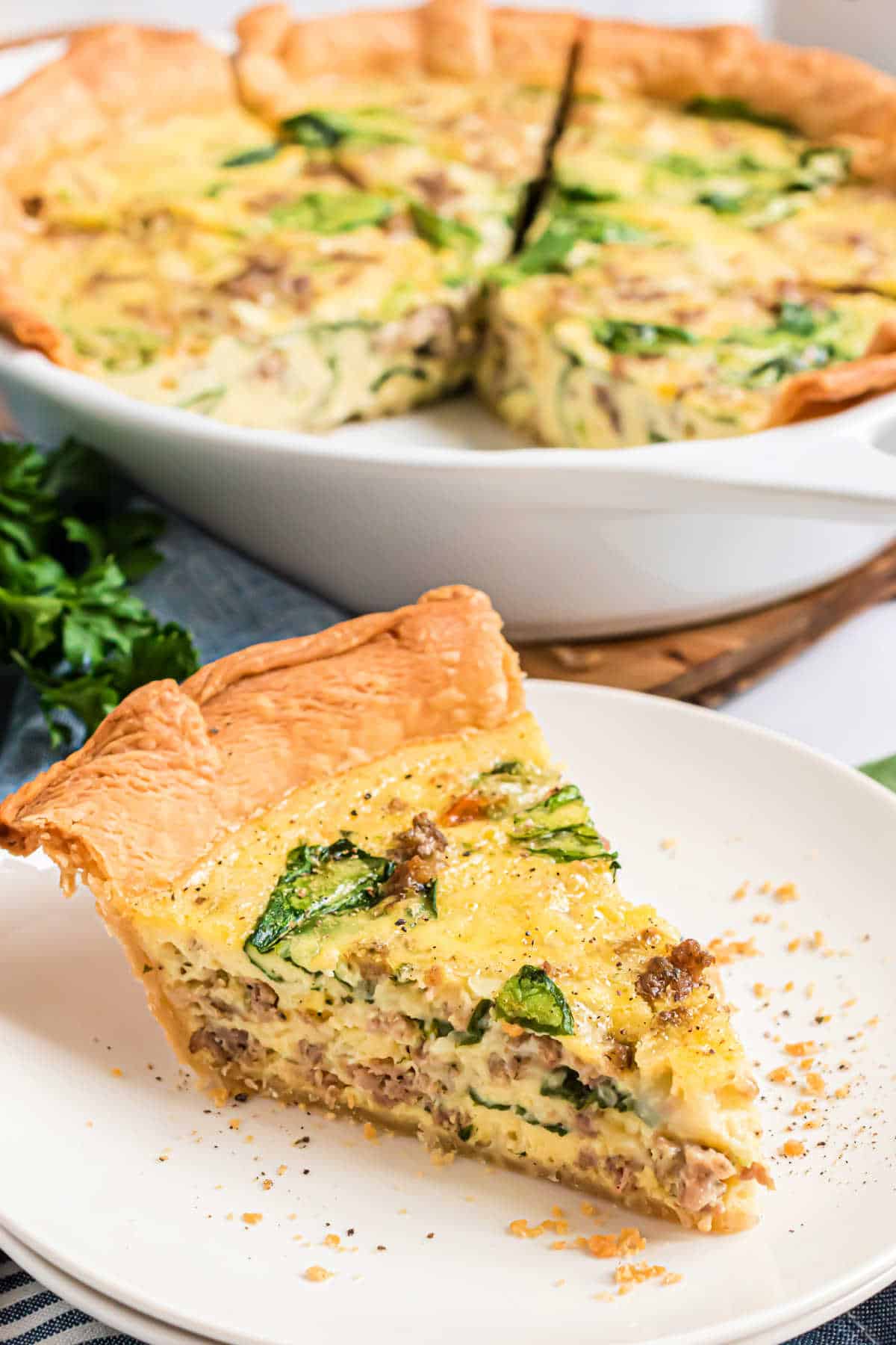Slice of spinach quiche on a plate.