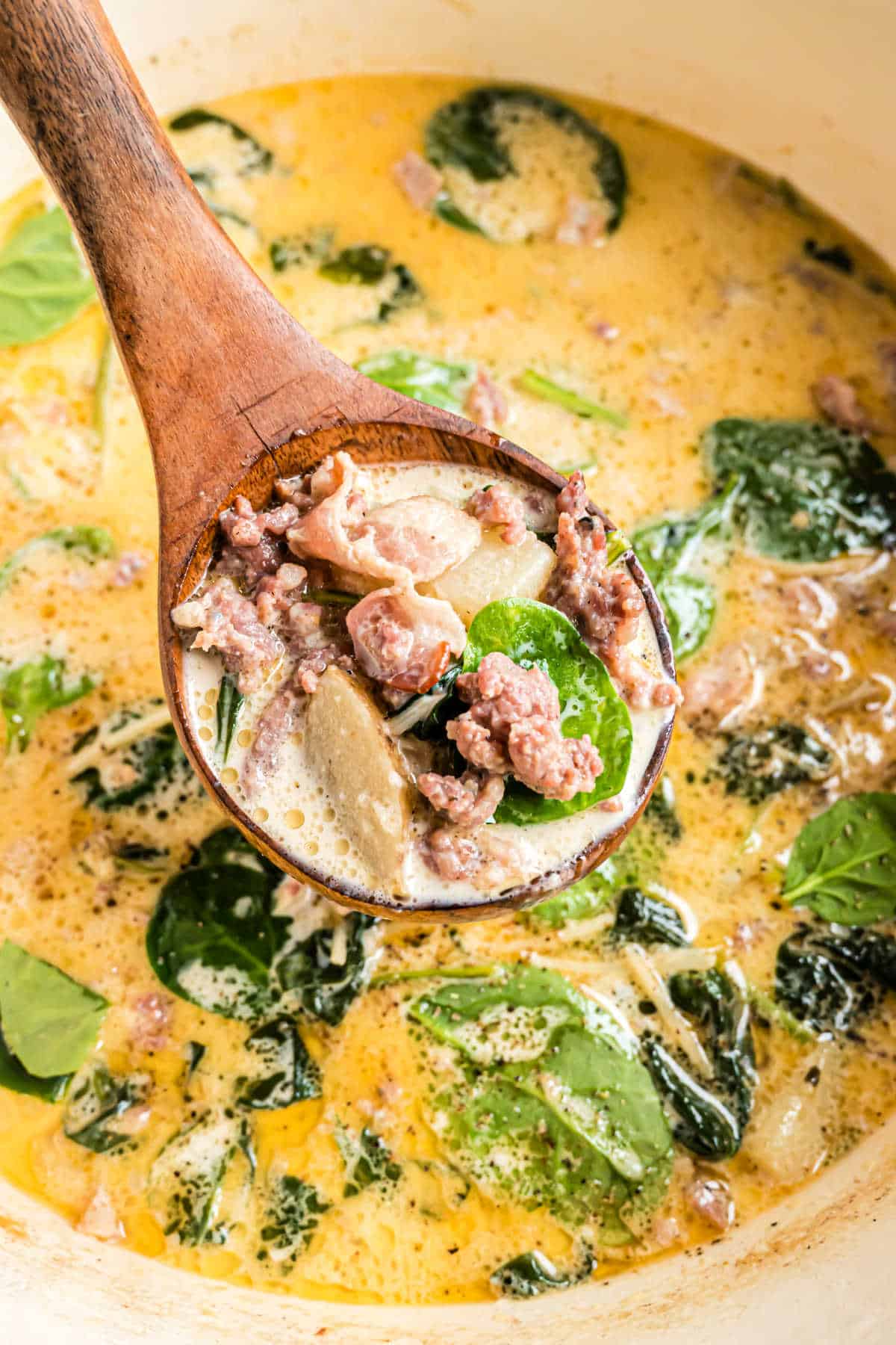 Soup pot with zuppa toscana soup and a ladle.