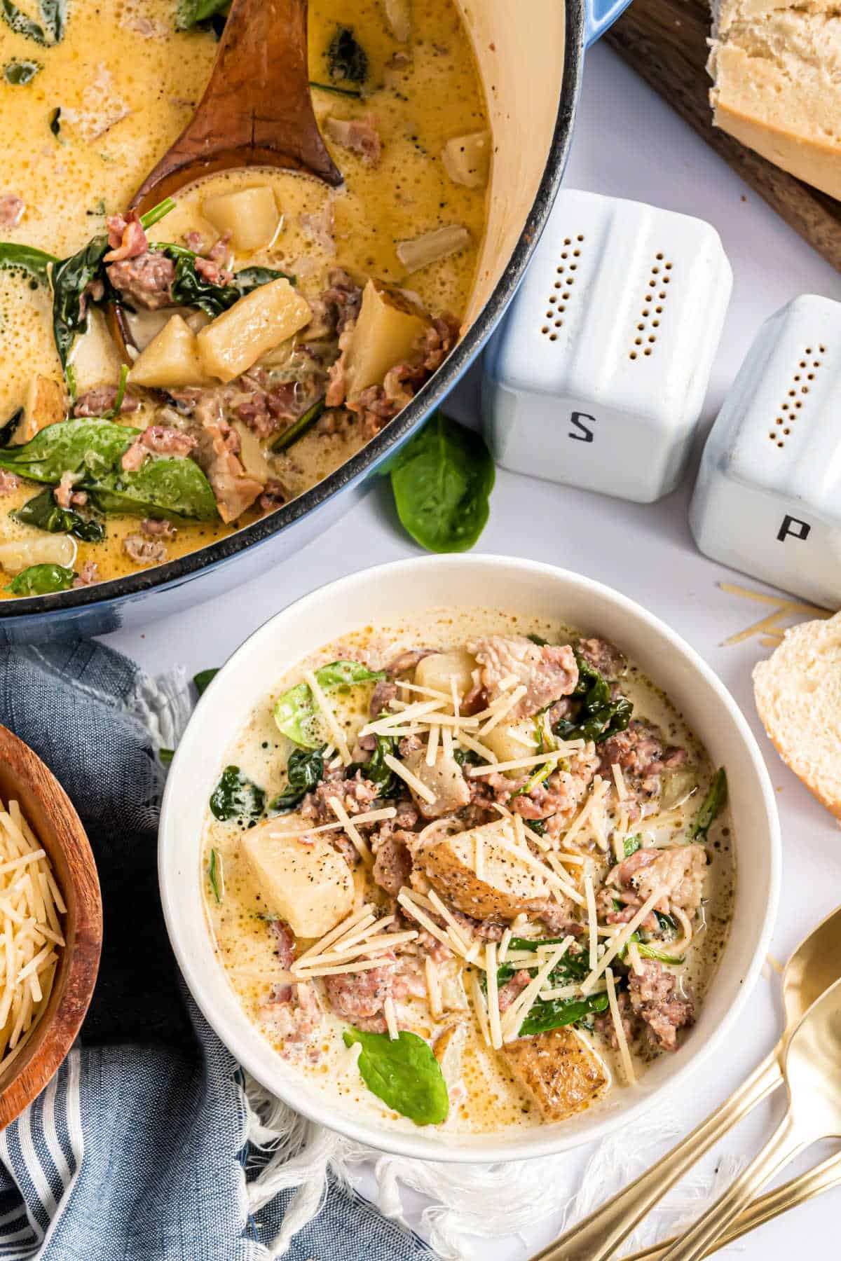 Bowl of zuppa toscana soup with shredded parmesan cheese on top.