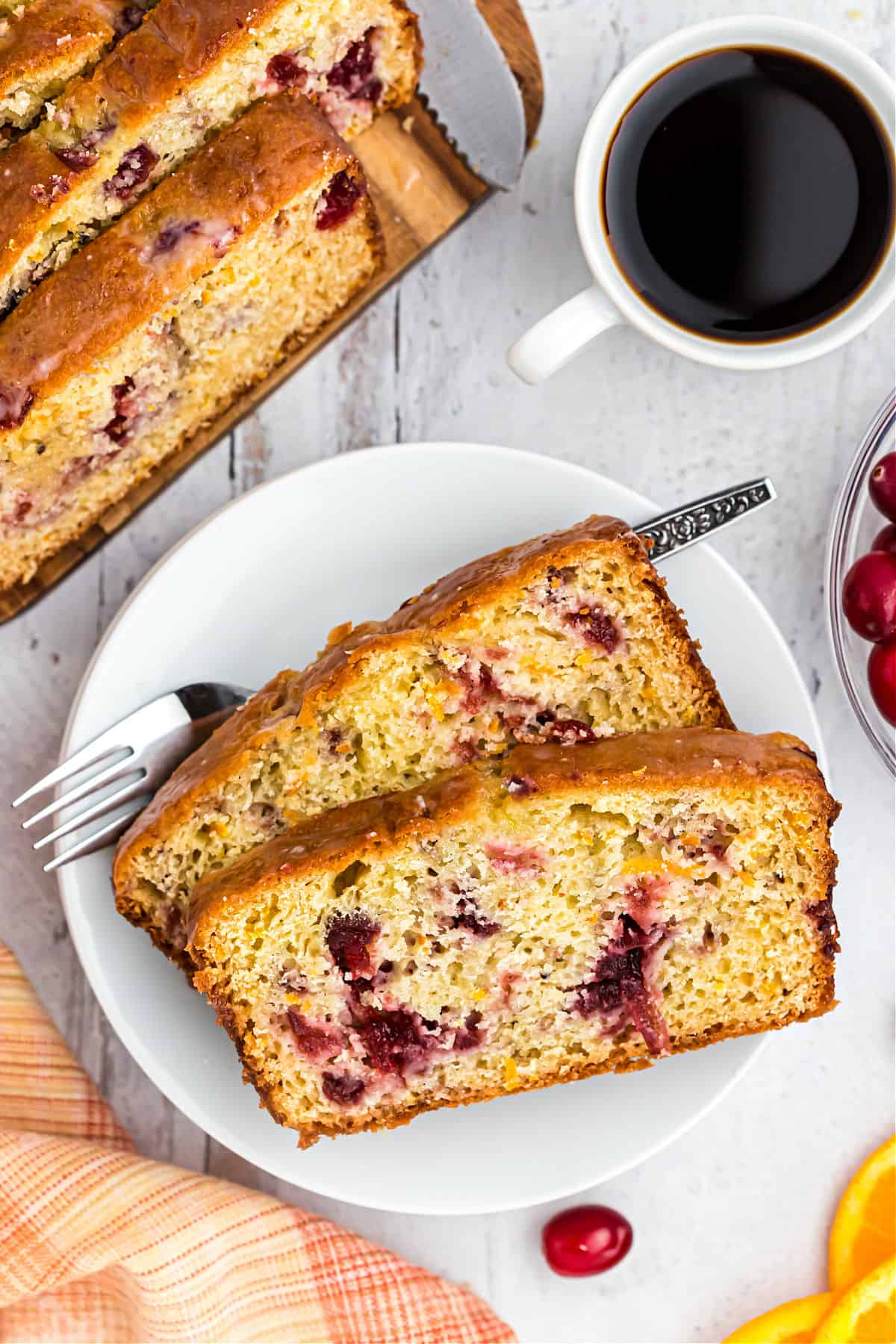 Cranberry bread served on a white plate with black coffee.