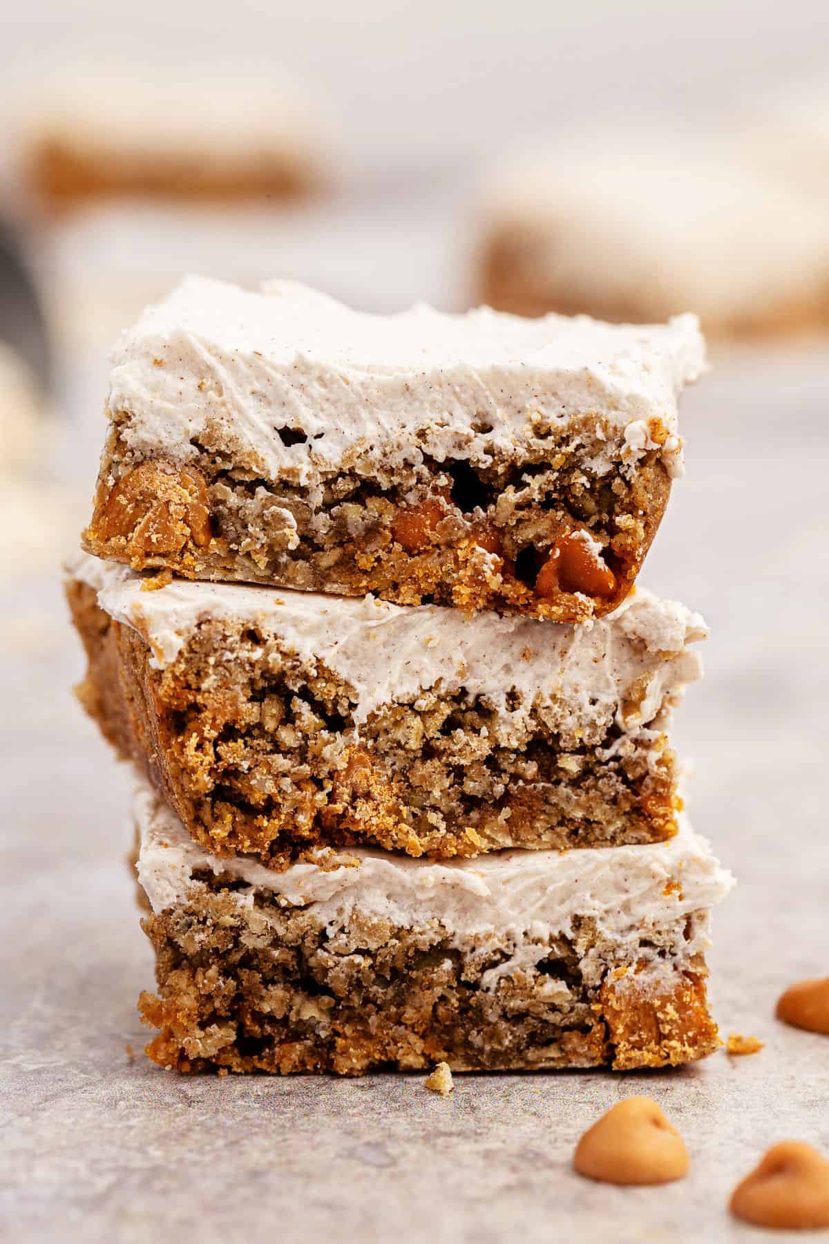 Stack of three frosted oatmeal butterscotch cookie bars.