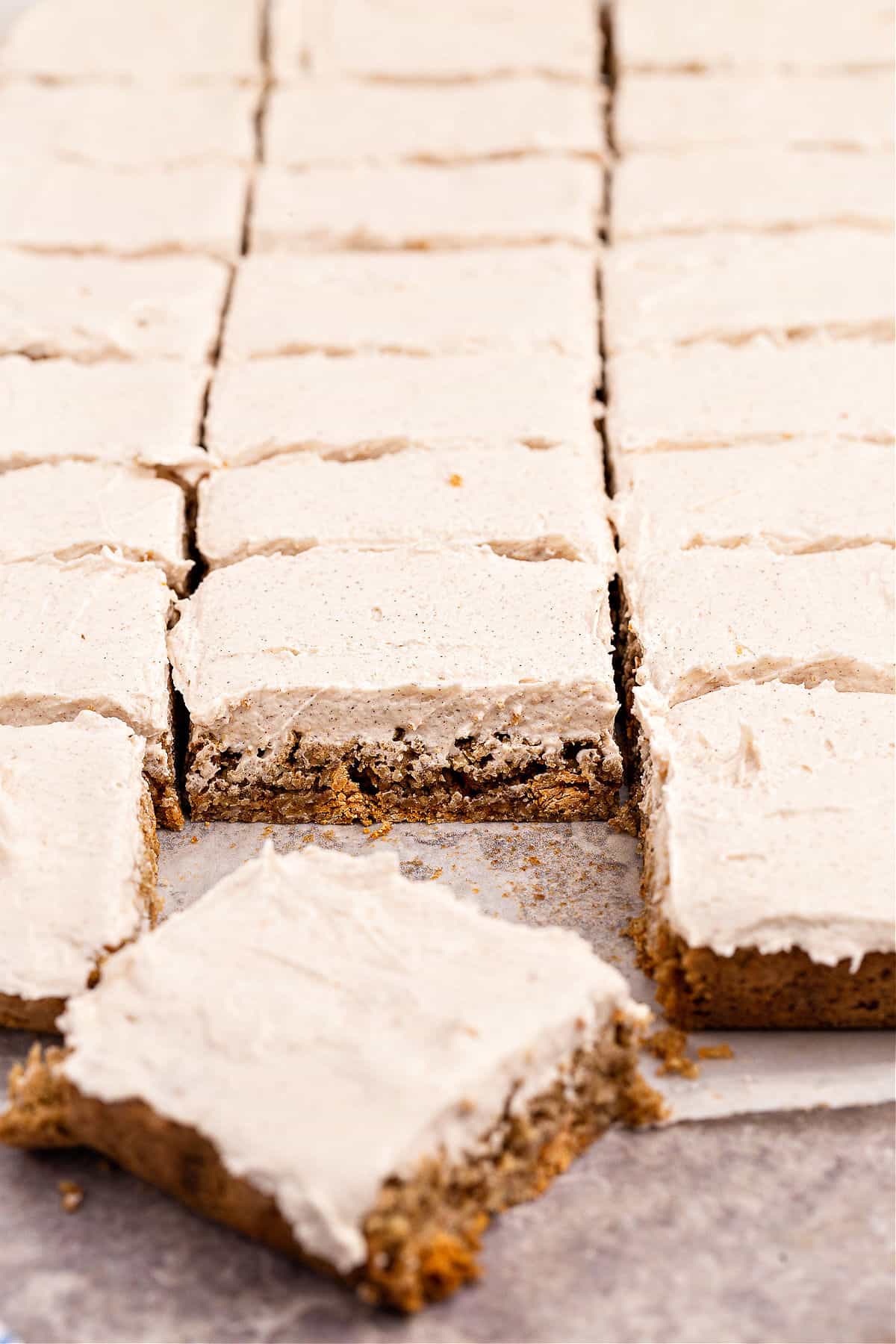 Oatmeal butterscotch cookie bars topped with cinnamon frosting and cut into squares.