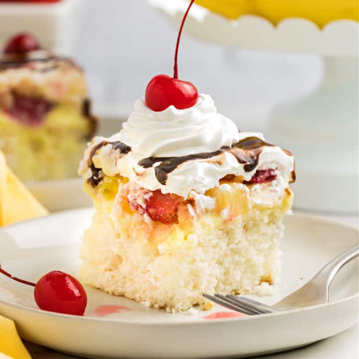 Banana Split Poke Cake is an easy cake recipe made with white cake mix. Topped with banana pudding, fresh berries and all the classic sundae fixings, it's the perfect dessert for summertime!