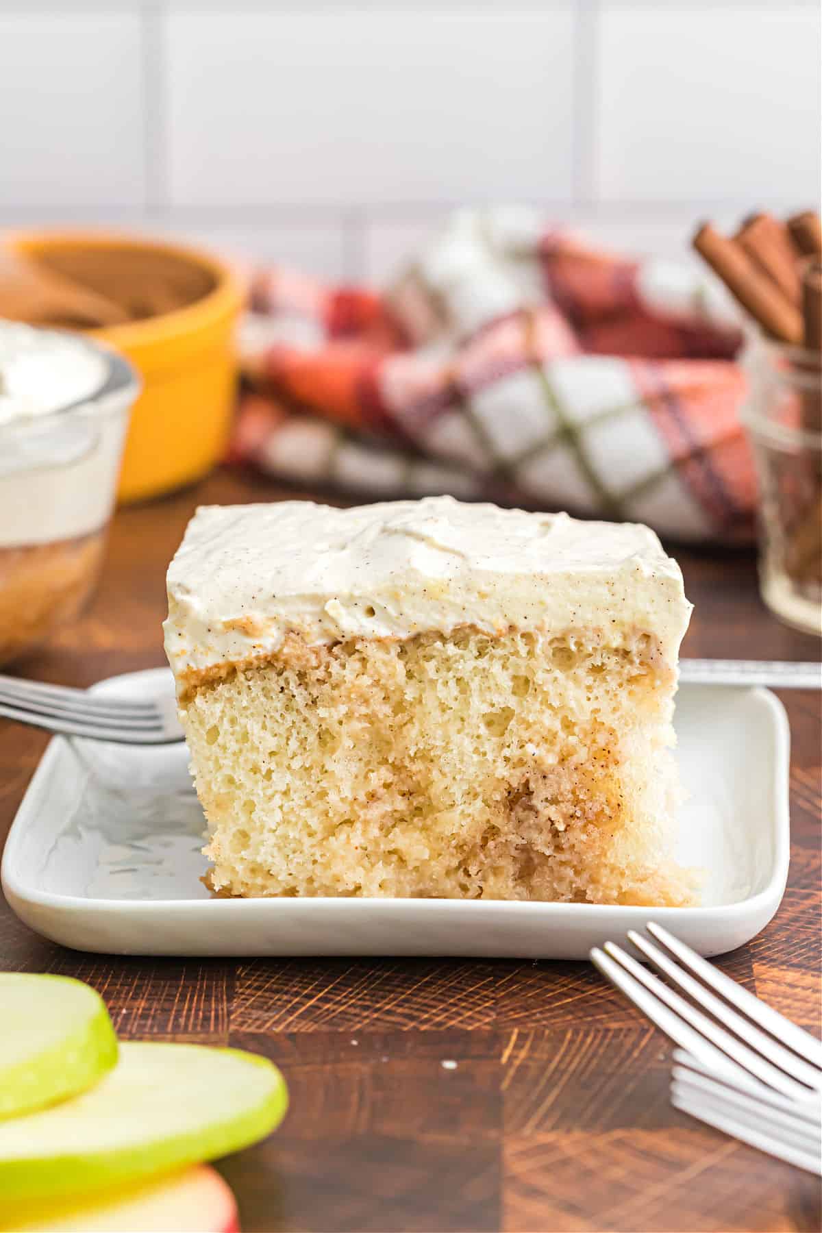 Slice of apple pie poke cake on a white plate.