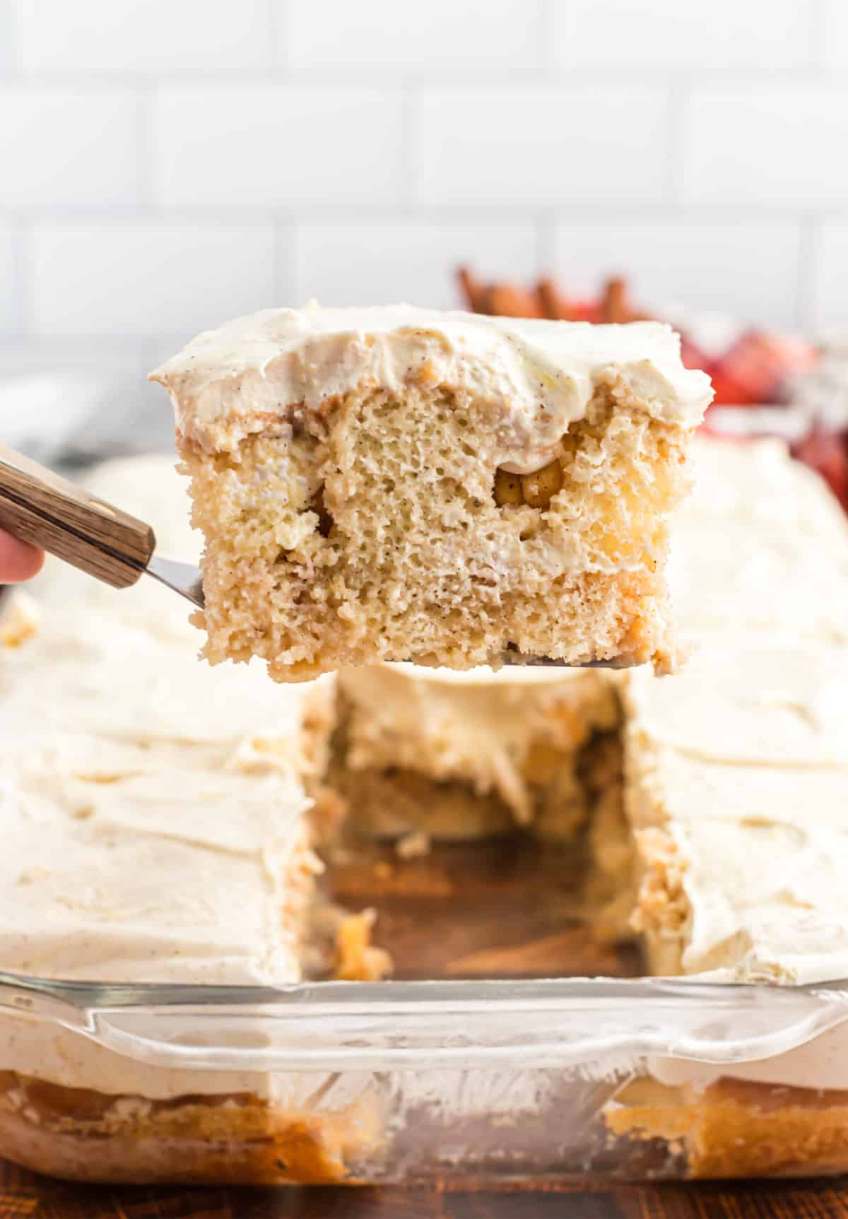 Slice of apple cake being lifted out of pan with spatula.