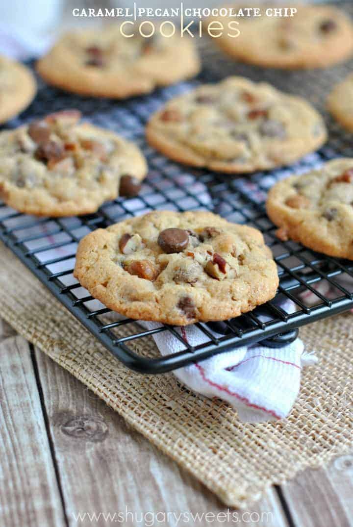 Chocolate chip cookies with pecans on a black wire cooling rack.