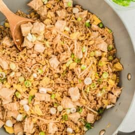 Chicken fried rice in a skillet garnished with green onions.