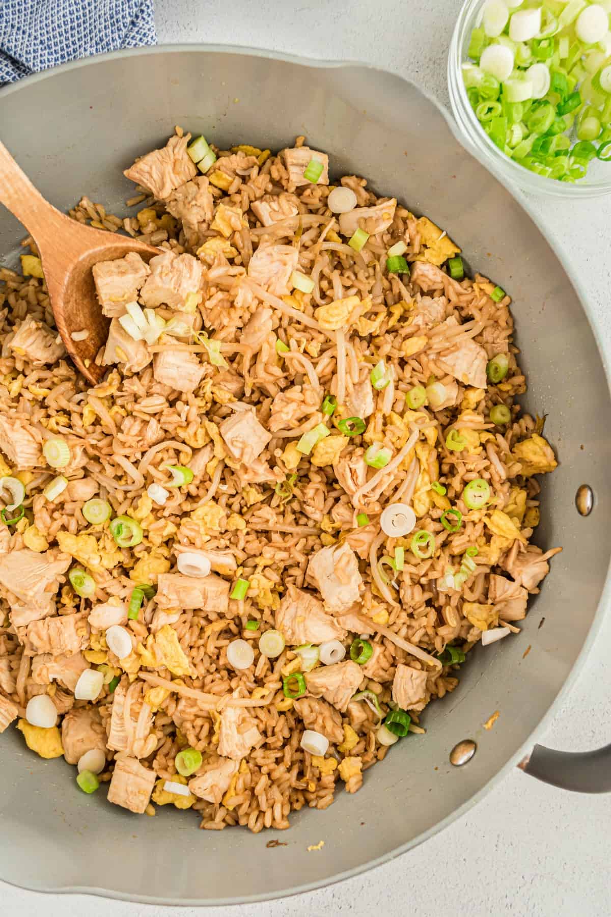 Chicken fried rice in a skillet garnished with green onions.
