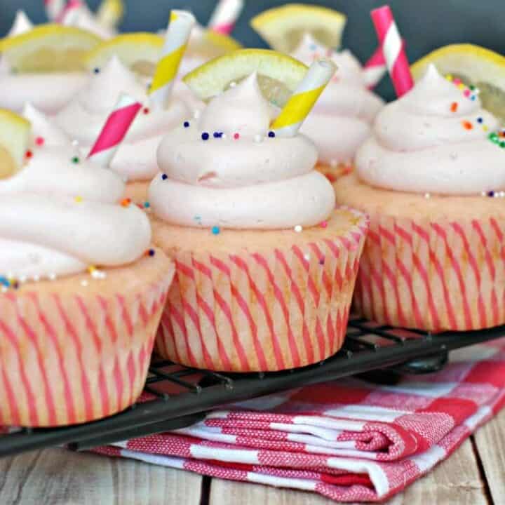 Pink lemonade cupcakes on wire cooling rack.