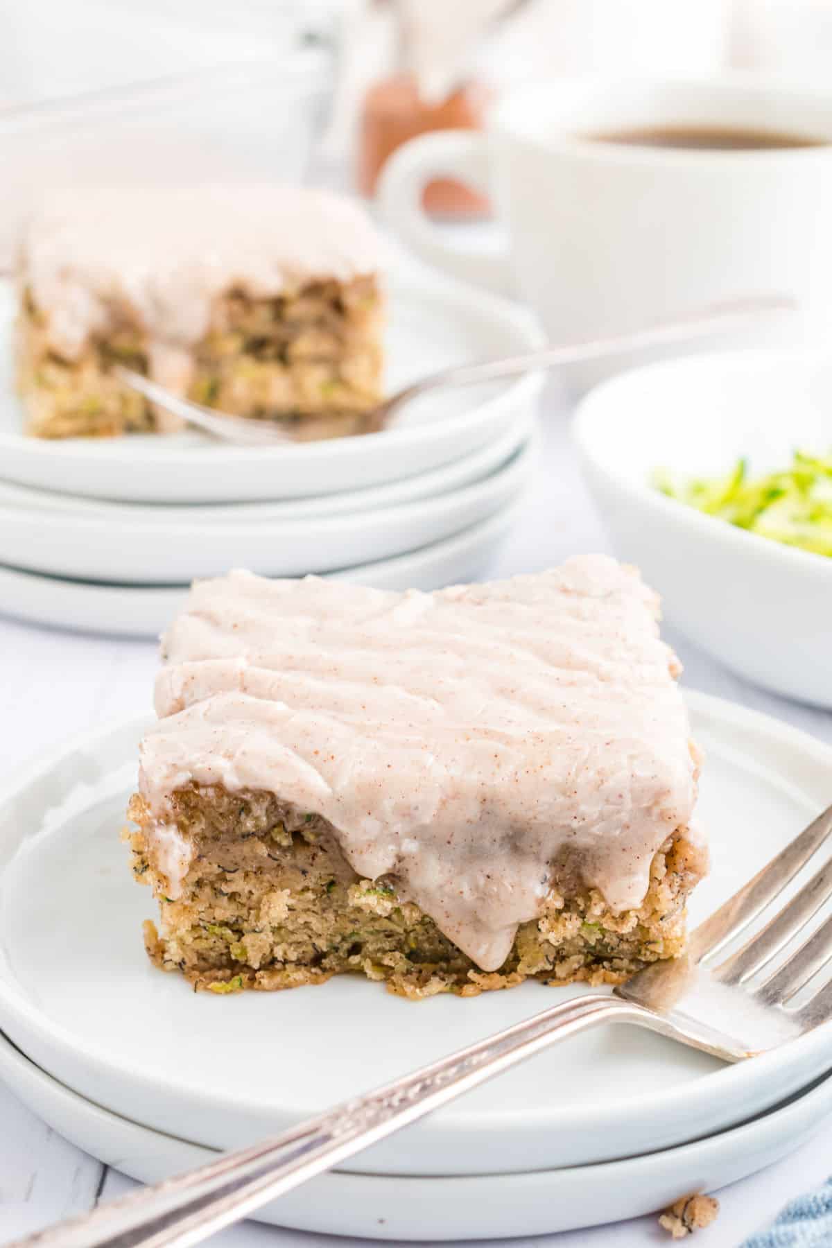 Banana zucchini bars with cinnamon icing on a white plate.