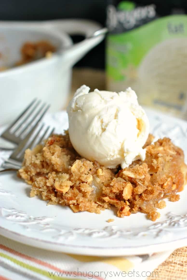 Peach Crisp topped with vanilla ice cream on a white plate! 