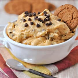 Pumpkin dip with chocolate chips in a white bowl with gingersnap dippers.