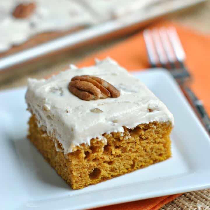 Slice of butter pecan frosted pumpkin bar on a white dessert plate.