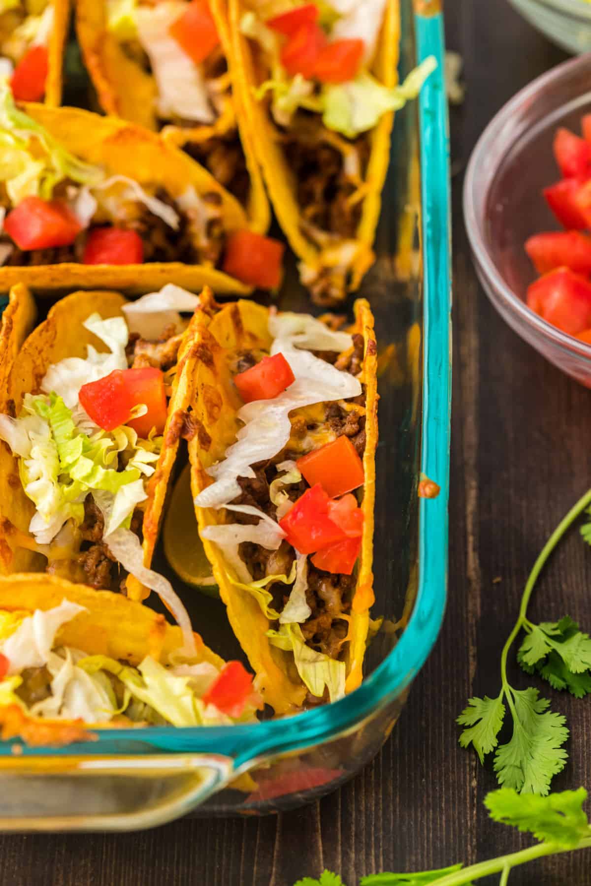 Baked tacos in clear glass baking dish,