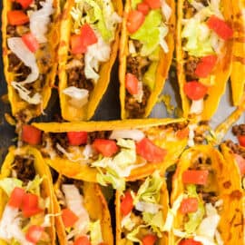 Baked Tacos in a 13x9 dish topped with lettuce and tomato.