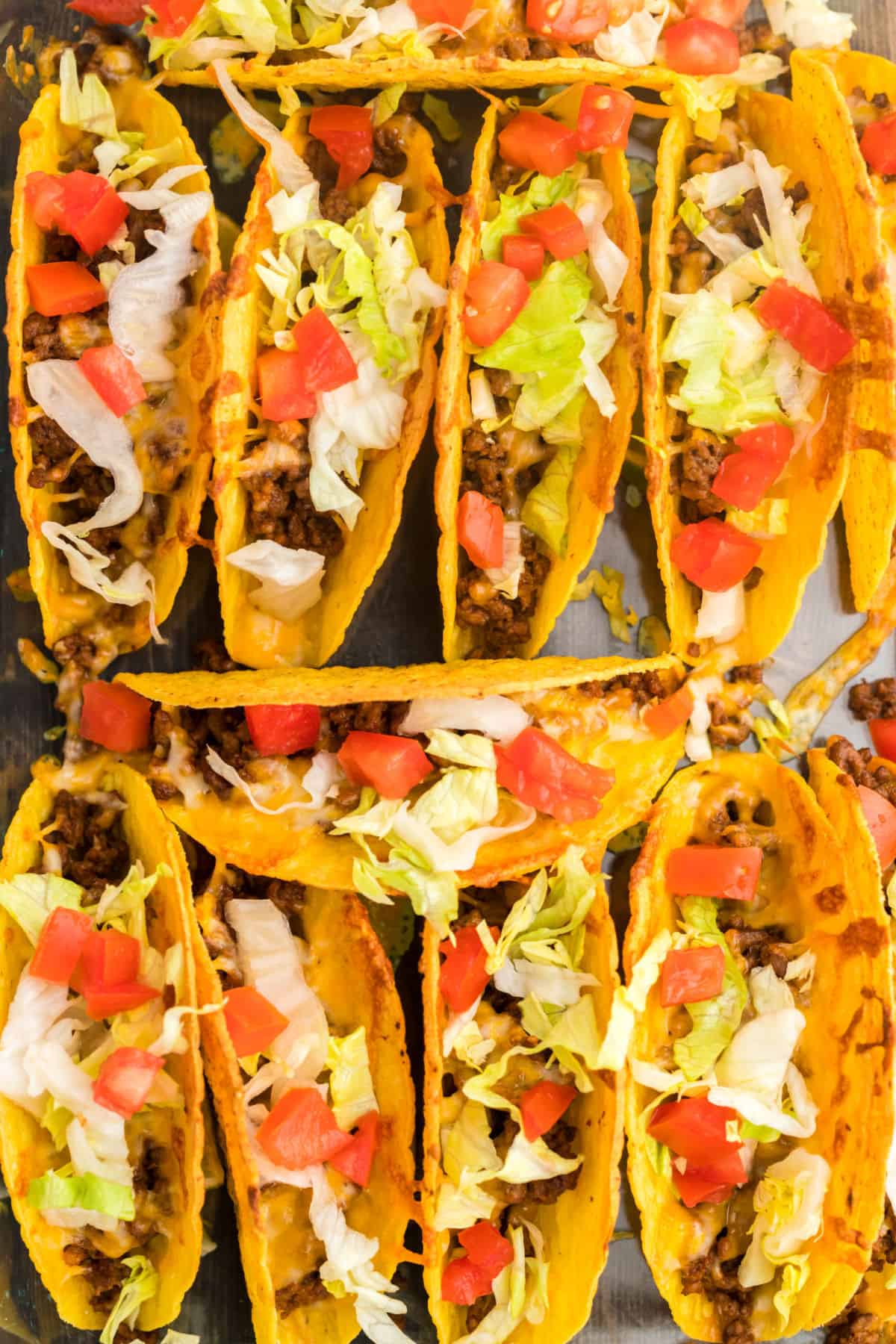 Baked Tacos in a 13x9 dish topped with lettuce and tomato.