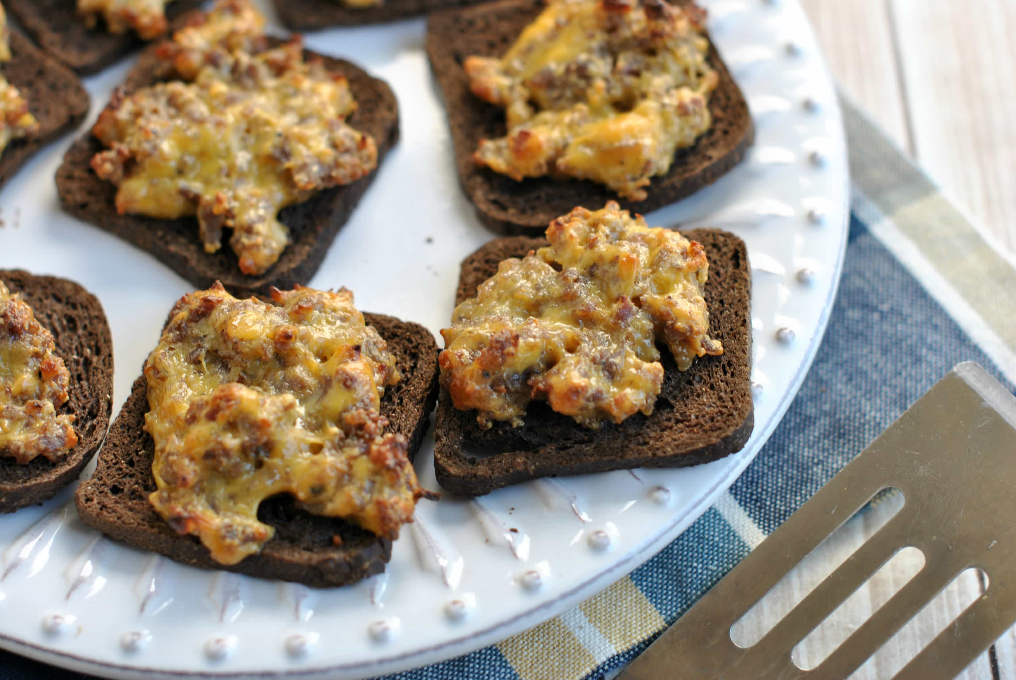 Spicy pork sausage with creamy velveeta baked on a slice of pumpernickel!