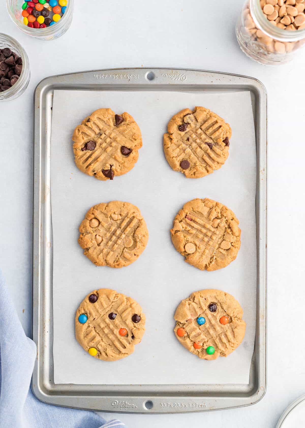 Peanut butter cookies on parchment paper lined cookie sheet.