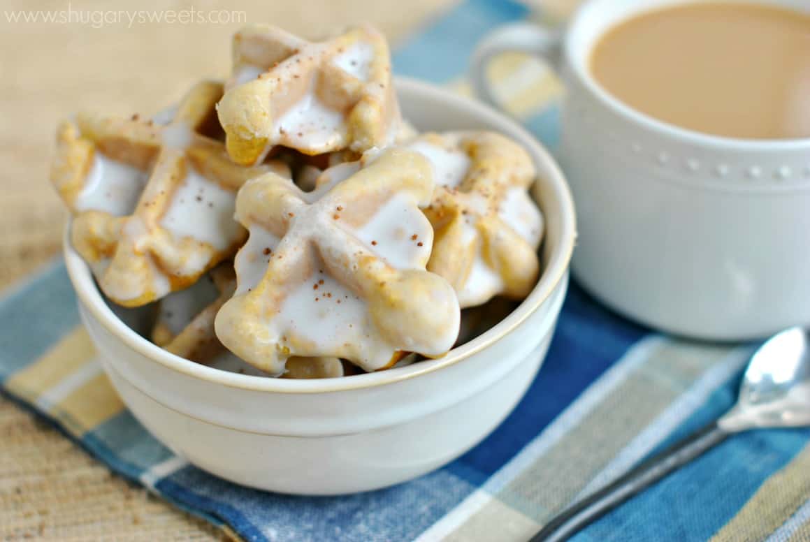 Mini pumpkin waffles in a white bowl with coffee.