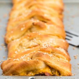 Easy Bacon Cheeseburger Braid gets dinner on the table in 30 minutes! Ground beef and your favorite burger fixings get wrapped in crescent roll dough and baked. A delicious party food or weeknight meal!
