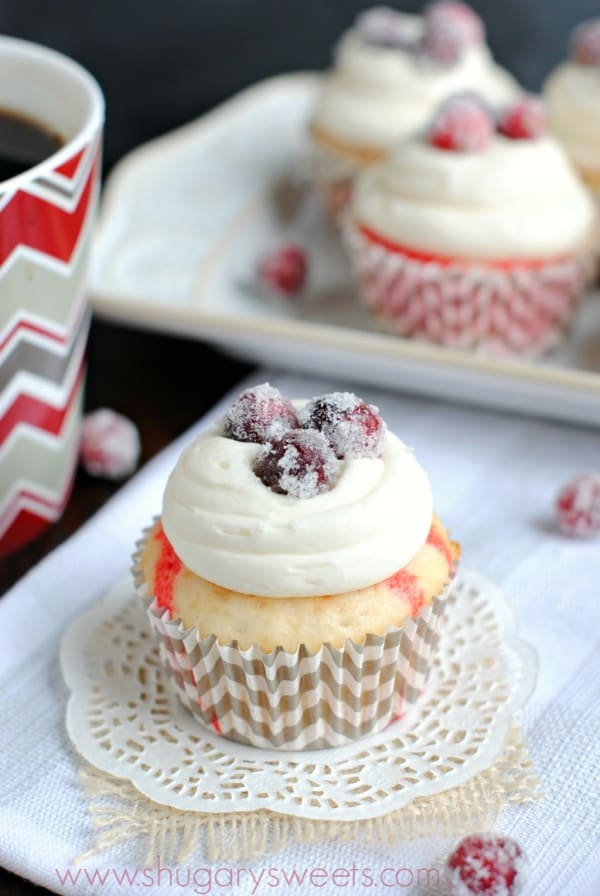 Cranberry poke cupcakes with sugared cranberries on top.