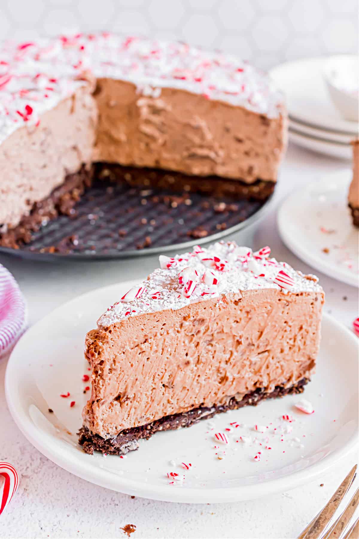 Slice of hazelnut mousse pie with candy canes on dessert plate.